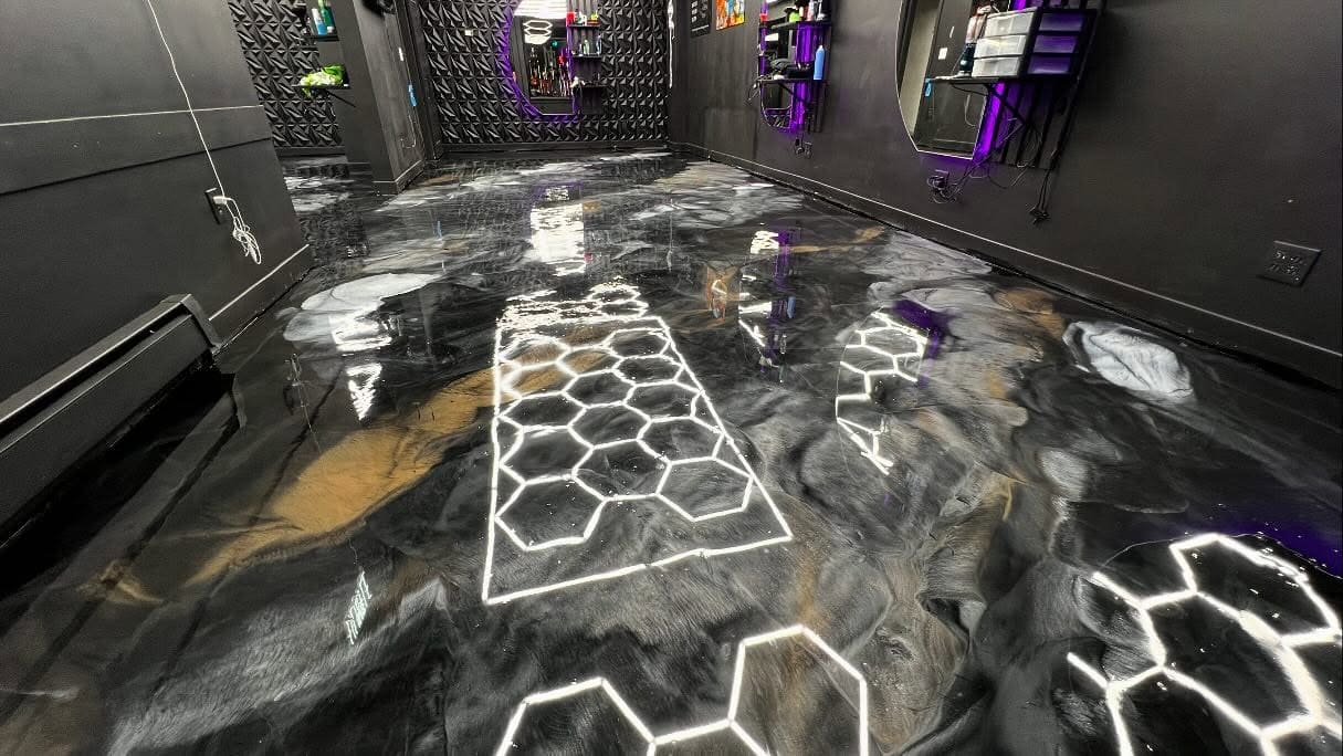 Barbershop with a dark metallic epoxy floor reflecting hexagonal lights