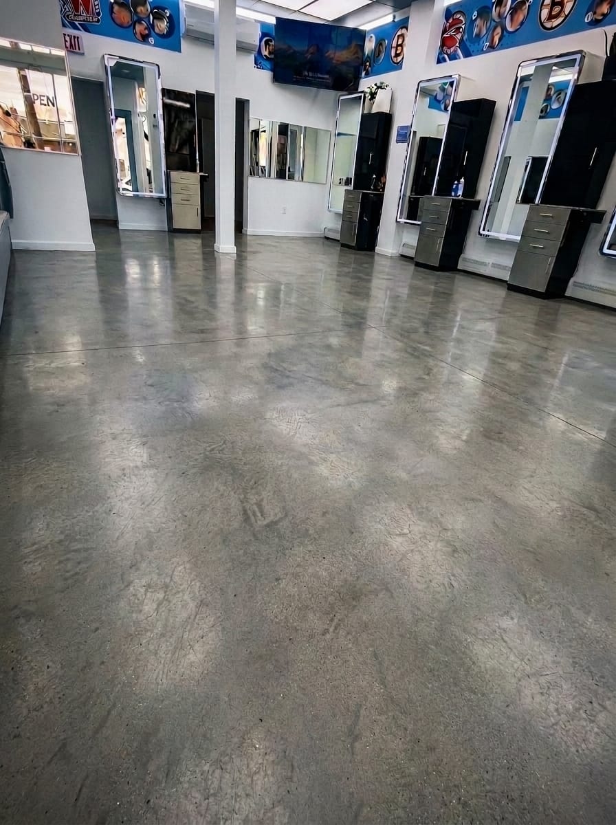 Barbershop floor before treatment: stained, patchy bare concrete